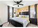 King-size bed, ceiling fan, and yellow accent wall in this spacious bedroom at 8843 Interlocking Ct, Davenport, FL 33896