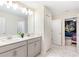 Modern bathroom with double vanity, a large mirror, and tiled floors at 8843 Interlocking Ct, Davenport, FL 33896