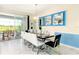Elegant dining room with large table, white chairs, and blue accent wall at 8843 Interlocking Ct, Davenport, FL 33896