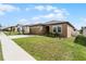 Tan one-story house with a two-car garage and green lawn at 928 Orchid Grove Blvd, Davenport, FL 33837