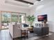 Bright living room with comfy seating, large TV, and sliding glass doors leading to backyard at 10564 Royal Cypress Way, Orlando, FL 32836