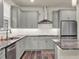 Modern kitchen with gray cabinets, granite countertops, and stainless steel appliances at 3286 Hanging Tide St, Winter Garden, FL 34787
