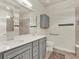 Modern bathroom with dual vanity, a large mirror, and accessible features at 3286 Hanging Tide St, Winter Garden, FL 34787