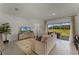 Living room with beige sofa, a TV, and sliding doors leading to the backyard at 3349 Private Oak Dr, Apopka, FL 32703