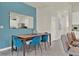 Dining room with a blue accent wall, wooden table, and blue velvet chairs at 684 Preston Cove Dr, St Cloud, FL 34771