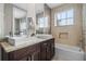 Bathroom with a bathtub, dual vanities and mosaic tile at 7540 Sunville Ave, Kissimmee, FL 34747