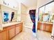 Bathroom with a bathtub, double vanity, and mirrored closet at 14650 Sweet Acacia Dr, Orlando, FL 32828