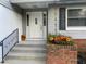 Front door entry with brick steps, iron railing, and seasonal flowers at 906 Red Oak Ct, Winter Springs, FL 32708