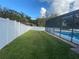 Large grassy backyard with a pool and a white vinyl fence at 906 Red Oak Ct, Winter Springs, FL 32708