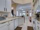 Open kitchen with white cabinets, a breakfast bar, and views into the dining and living areas at 1102 Golf Course Pkwy, Davenport, FL 33837