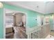 Upstairs hallway with access to bedrooms and bathroom, featuring light teal walls and wood flooring at 1820 Blaine Ter, Winter Park, FL 32792