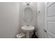 Modern powder room with pedestal sink and oval mirror at 2321 Lobelia Dr, Lake Mary, FL 32746