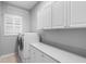 Laundry room with washer, dryer, and upper cabinets at 2626 Raccoon Run Ln, Orlando, FL 32837