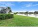 Grass backyard with lake view, partially screened patio at 2626 Raccoon Run Ln, Orlando, FL 32837