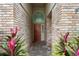 Brick entryway with arched detail and red door at 2626 Raccoon Run Ln, Orlando, FL 32837
