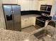 Modern kitchen with white cabinets, granite countertops, and stainless steel appliances at 3468 Soho St # 107, Orlando, FL 32835