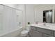 Clean bathroom with a tub, toilet and vanity with gray cabinets at 5937 High Seas Dr, Orlando, FL 32821
