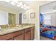 Double vanity bathroom with granite countertop and view into a bedroom at 1423 Thunderbird Rd, Davenport, FL 33896