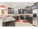 Modern kitchen with dark cabinetry, stainless steel appliances, and an island with seating at 1423 Thunderbird Rd, Davenport, FL 33896