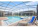 Screened-in pool and spa with lounge chairs in a backyard setting at 1423 Thunderbird Rd, Davenport, FL 33896