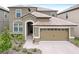 Two-story house with a large, attached garage and landscaped front yard at 1423 Thunderbird Rd, Davenport, FL 33896