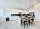Modern kitchen with white cabinets, stainless steel appliances, and a breakfast bar at 1490 Olympic Club Blvd, Champions Gate, FL 33896