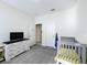 Bright bedroom with crib, dresser, and access to a nearby bathroom at 1490 Olympic Club Blvd, Champions Gate, FL 33896
