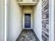 Covered entryway with a dark blue door and a stone accent wall at 1490 Olympic Club Blvd, Champions Gate, FL 33896