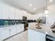 Modern kitchen with white cabinets, gray countertops, and stainless steel appliances at 1490 Olympic Club Blvd, Champions Gate, FL 33896