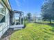 Landscaped backyard with screened enclosure and grassy area at 1490 Olympic Club Blvd, Champions Gate, FL 33896