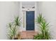 Front door entry with blue door and terracotta tile flooring at 235 Royal Palm Dr, Davenport, FL 33837