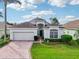 Attractive one-story home with a two-car garage and well-manicured lawn at 235 Royal Palm Dr, Davenport, FL 33837