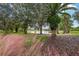 Serene lakeside view with palm trees and pink muhly grass at 235 Royal Palm Dr, Davenport, FL 33837