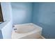 Clean bathroom with a tub, light blue walls, and a tiled floor at 2713 Sw 158Th St, Ocala, FL 34473
