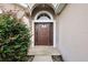 House's front entrance with a brown door and arched window at 2713 Sw 158Th St, Ocala, FL 34473