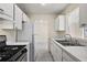Kitchen with white cabinets, gas stove and double sink at 3375 Sw 147Th Lane Rd, Ocala, FL 34473
