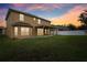 Two-story house with a covered patio and spacious backyard at sunset at 6526 Lake Pembroke Pl, Orlando, FL 32829