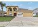 Two-story home with arched entryway and three car garage at 6526 Lake Pembroke Pl, Orlando, FL 32829