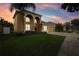 Two-story house with a two-car garage and landscaped yard at dusk at 6526 Lake Pembroke Pl, Orlando, FL 32829