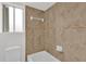 Bathroom with beige tile, shower/tub combo, and window at 14646 Brightwell Ct, Orlando, FL 32824