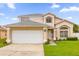 Two-story house with a white garage door and landscaped lawn at 14646 Brightwell Ct, Orlando, FL 32824