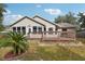 House back view, highlighting the deck and landscaping at 23 Spring Ridge Dr, Debary, FL 32713