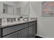 Double vanity bathroom with granite countertops and gray cabinets at 2626 Sage Valley Way, Winter Haven, FL 33884