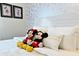 Close-up of a bed with Mickey and Minnie Mouse plush toys at 3053 Gatsby St, Kissimmee, FL 34746