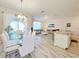 Open concept dining area with glass table and white chairs at 3053 Gatsby St, Kissimmee, FL 34746