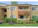 Two-story building with balcony, landscaping, and manicured lawn at 604 Kenwick Cir # 202, Casselberry, FL 32707