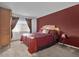 Spacious bedroom with king-size bed and dark red accent wall at 604 Kenwick Cir # 202, Casselberry, FL 32707