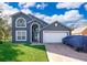 Two-story house with gray exterior, white garage door, and landscaped yard at 709 Lake Emerald Ave, Orange City, FL 32763
