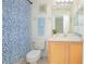Bathroom with a blue and white shower curtain and wood vanity at 121 Palermo St, Davenport, FL 33897