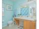 Bathroom with light blue walls, wood vanity and a shower/tub combo at 121 Palermo St, Davenport, FL 33897